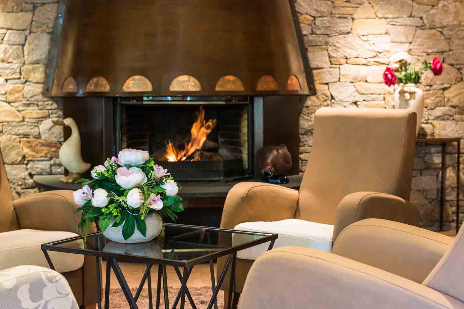 Sala amb llar de foc encesa a l'Aparthotel Els Meners