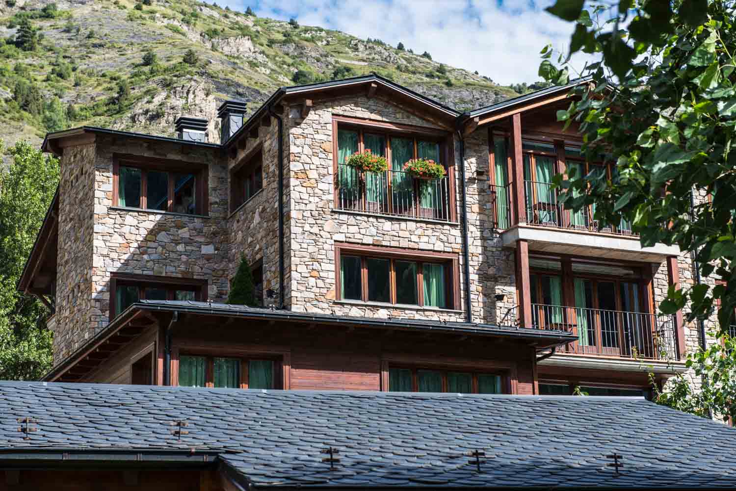 Façana de pedra i fusta de l'Aparthotel Els Meners, a Canillo